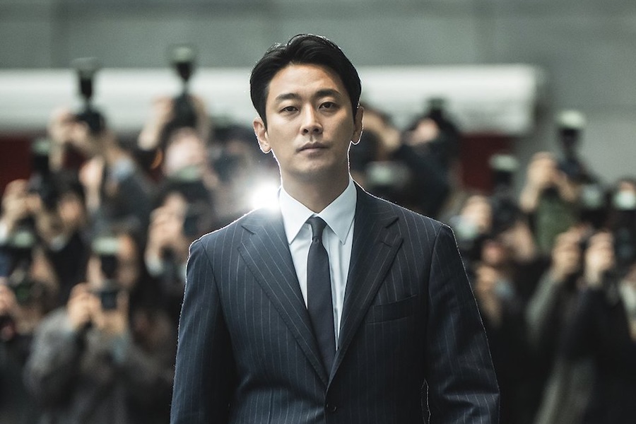 A tense scene from Climax, featuring a character in a dark suit looking intensely.