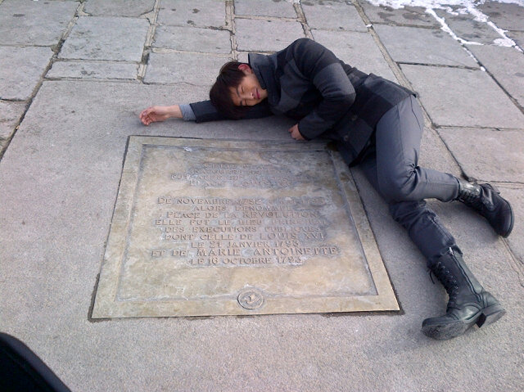 2PM’s Taecyeon Lies on Bare Ground and Junsu Fools Around in France